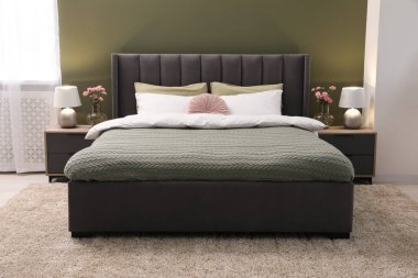 Lüks bir odada büyük, rahat bir yatak, lambalar ve güzel çiçekler. İç tasarım