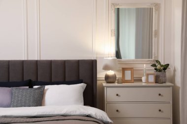 Şık bir yatak odası, geniş konforlu yatak odası ve çekmeceler.