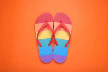 Turuncu arka planda gökkuşağı terlikleri, düz yatış. LGBT gururu