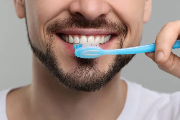 Άνθρωπος Βουρτσίζει Δόντια Του Πλαστική Οδοντόβουρτσα Ανοιχτό Γκρι Φόντο Κοντινό — Φωτογραφία Αρχείου