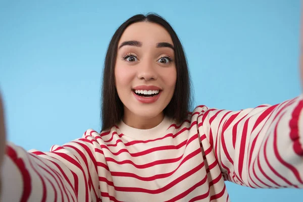 Uśmiechnięta Młoda Kobieta Robi Selfie Jasnoniebieskim Tle — Zdjęcie stockowe