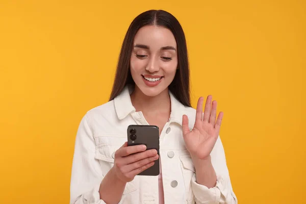 Jovem Feliz Olhando Para Smartphone Acenando Olá Fundo Amarelo — Fotografia de Stock