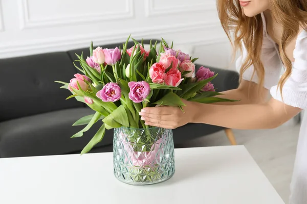 美しいチューリップの花束を屋内ホワイトテーブルに置く女性 クローズアップ — ストック写真