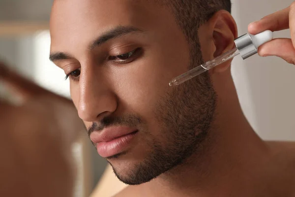 Schöner Mann Anwendung Kosmetischen Serums Auf Gesicht Drinnen Nahaufnahme — Stockfoto