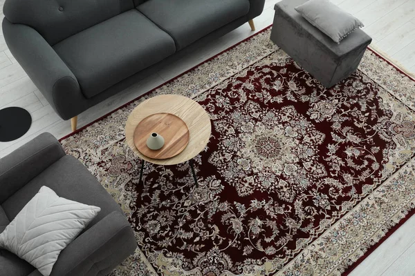 Cozy room interior with stylish furniture and soft carpet with beautiful pattern, view from above