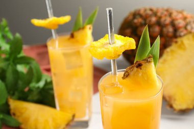 Lezzetli ananas kokteyli ve dilimlenmiş meyve masada, yakın plan.