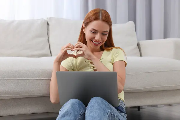 在家里通过笔记本电脑进行视频聊天时 女人正在用手制造心灵 远距离关系 — 图库照片