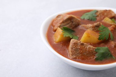 Açık gri masada kasede leziz gulaş, yakın plan. Metin için boşluk