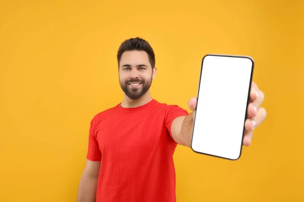 Hombre Joven Mostrando Teléfono Inteligente Mano Sobre Fondo Amarillo —  Fotos de Stock
