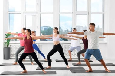 Paspaslar üzerinde yoga yapan bir grup insan.