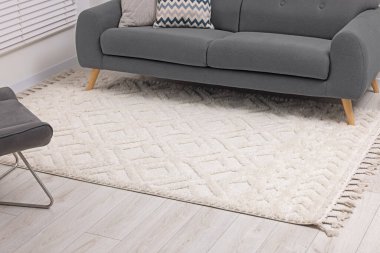 Oturma odasında yumuşak halı ve şık bir kanepe. Modern iç mimari