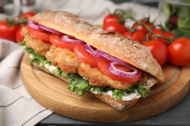 Gri ahşap masada şnitzel ile nefis bir sandviç.