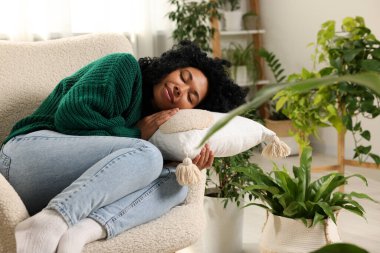 Rahatlatıcı atmosfer. Evdeki güzel çiçeklerin yanında uyuyan bir kadın.