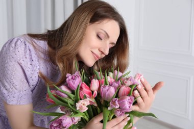 Güzel lalelerle dolu bir buketi olan genç bir kadın.