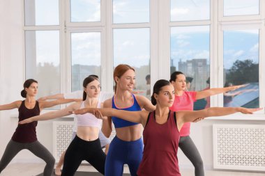 Yoga koçu, grup derslerinde kadınlara yardım ediyor.