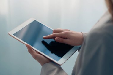 Bulanık arkaplanda modern tablet kullanan kadının yakın görüntüsü
