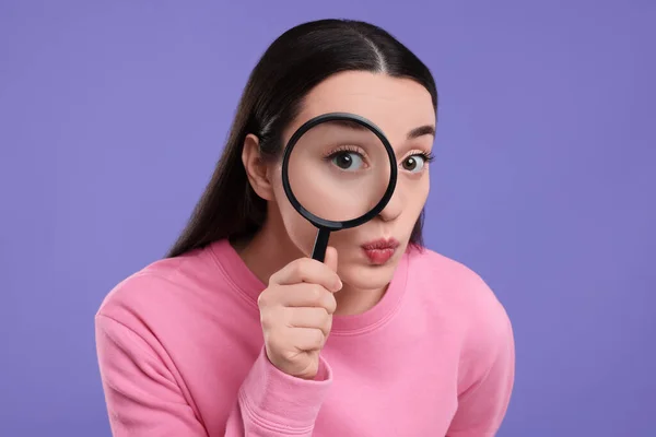 Mujer Joven Confundida Mirando Través Lupa Sobre Fondo Púrpura —  Fotos de Stock