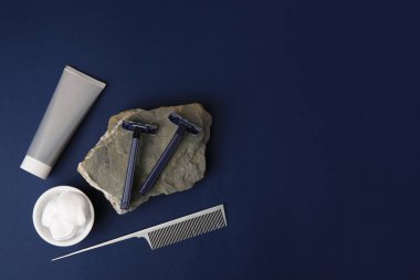 Mavi arka plandaki erkekler için traş aksesuarlarıyla düz konum