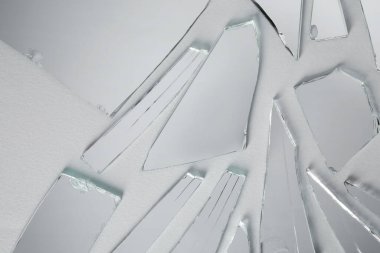 Beyaz arka planda kırık ayna parçaları, üst görünüm