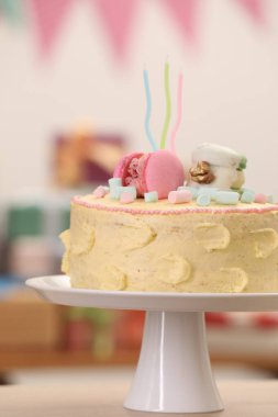 Masada bulanık arka planda makarna ve şekerlemelerle süslenmiş lezzetli bir pasta.