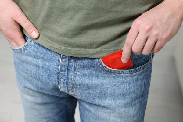 Mężczyzna Wyciągający Prezerwatywę Kieszeni Rozmytym Tle Zbliżenie — Zdjęcie stockowe