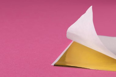 Pembe arka planda yenilebilir altın yaprak örtüsü, yakın plan. Metin için boşluk