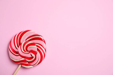 Pembe arka planda renkli lolipop kıvrımlı, üst manzaralı. Metin için boşluk