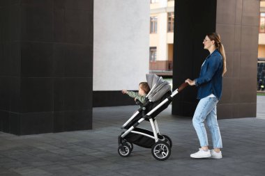 Bebek arabasıyla gezen sevimli bir çocukla güzel bir dadı.