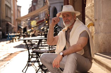 Yakışıklı son sınıf öğrencisi kapının önünde oturuyor, mesaj için yer var.