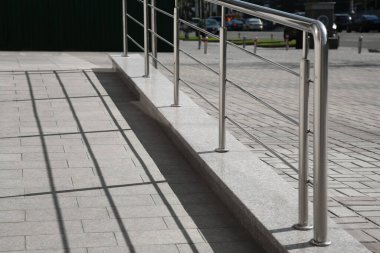 Dışarıdaki binanın yanında metal parmaklıklı bir rampa.