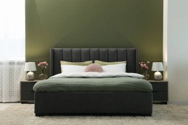 Lüks bir odada büyük, rahat bir yatak, lambalar ve güzel çiçekler. İç tasarım