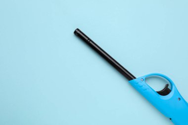 Açık mavi arka planda bir gaz çakmağı, üst manzara. Metin için boşluk