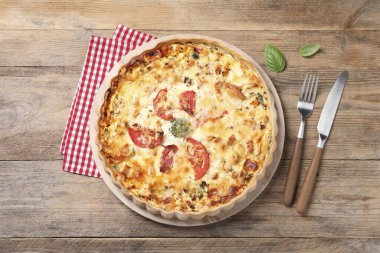 Tahta masada servis edilen domatesli ve peynirli kiş.