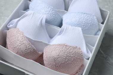 Açık gri mermer masa üzerinde katlanmış kadın iç çamaşırlı organizatör, yakın plan.