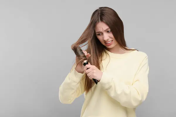 Femme Bouleversée Brossant Les Cheveux Sur Fond Gris Espace Pour — Photo