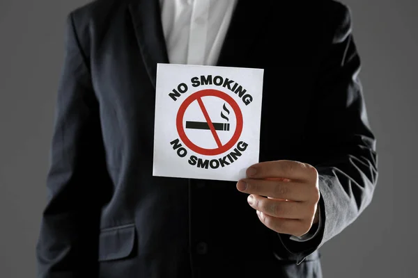 Man Holding Card Smoking Sign Gray Background Closeup — Stock Photo, Image