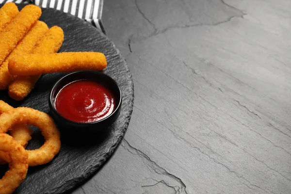 Smaklig Ketchup Lökringar Och Ostpinnar Grått Strukturerat Bord Närbild Plats — Stockfoto