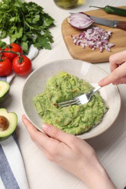 Beyaz ahşap masada nefis guacamole hazırlayan kadın, yakın plan.