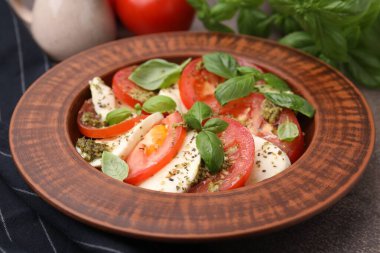 Masada pesto soslu bir tabak lezzetli Caprese salatası.