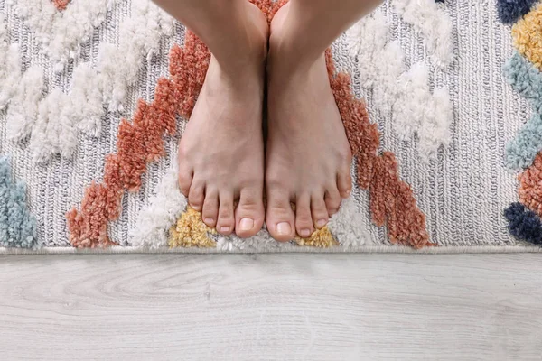 Kadın halıda dikiliyor, evde, üst manzaralı.