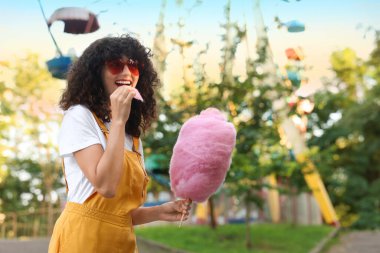 Lunaparkta pamuk şeker yiyen mutlu bir kadın. Metin için boşluk