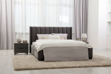 Yumuşak renkli, rahat yataklı ve komodinli şık bir yatak odası. İç tasarım