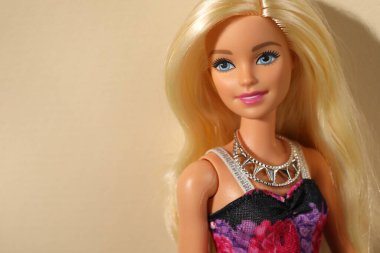 Mykolaiv, Ukrayna - 4 Eylül 2023: Bej arka planda kolye takan güzel Barbie bebek, metin için yer
