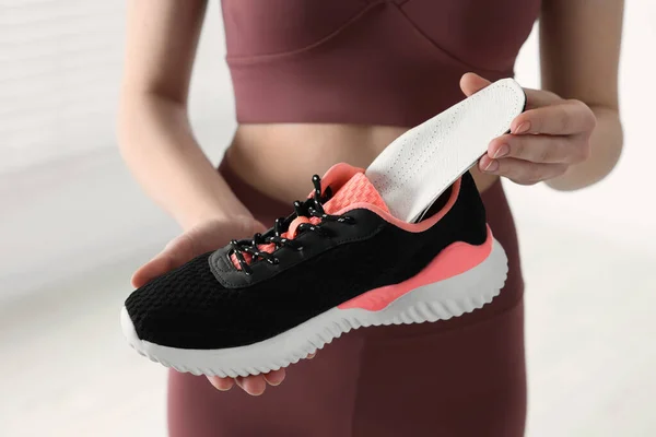 Sportliche Frau Die Orthopädische Einlegesohle Den Schuh Steckt Auf Verschwommenem — Stockfoto