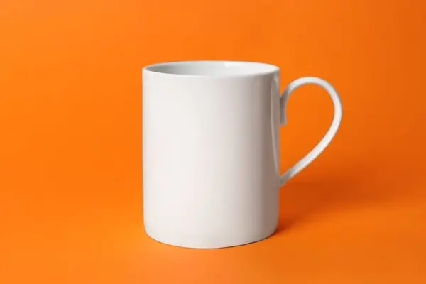 オレンジ色の背景に1つの白い陶磁器のマグ — ストック写真