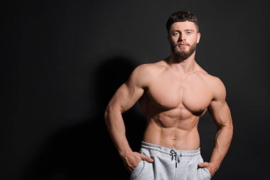 Siyah arka planda yakışıklı kaslı adam, mesaj için yer var. Seksi vücut.