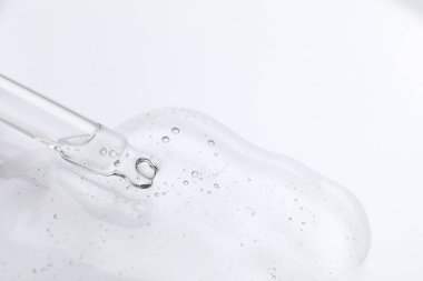 Pipetten ışık yüzeyine kozmetik yağ damlatıyor, yakın plan. Metin için boşluk