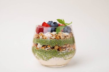 Chia matcha pudingi ve bej arkaplanlı böğürtlenli lezzetli yulaf ezmesi. Sağlıklı kahvaltı.