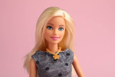 Mykolaiv, Ukrayna - 2 Eylül 2023: Soluk pembe arka planda güzel Barbie bebek