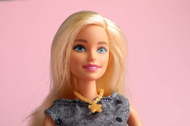 Mykolaiv, Ukrayna - 2 Eylül 2023: Soluk pembe arka planda güzel Barbie bebek